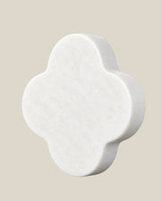ALHAMBRA Door Knob by ATOMS in White, angled view showing the rounded stone edge and natural mineral pattern.