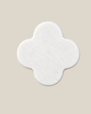 ALHAMBRA Door Knob by ATOMS in White, front view of the four-lobed natural stone face.