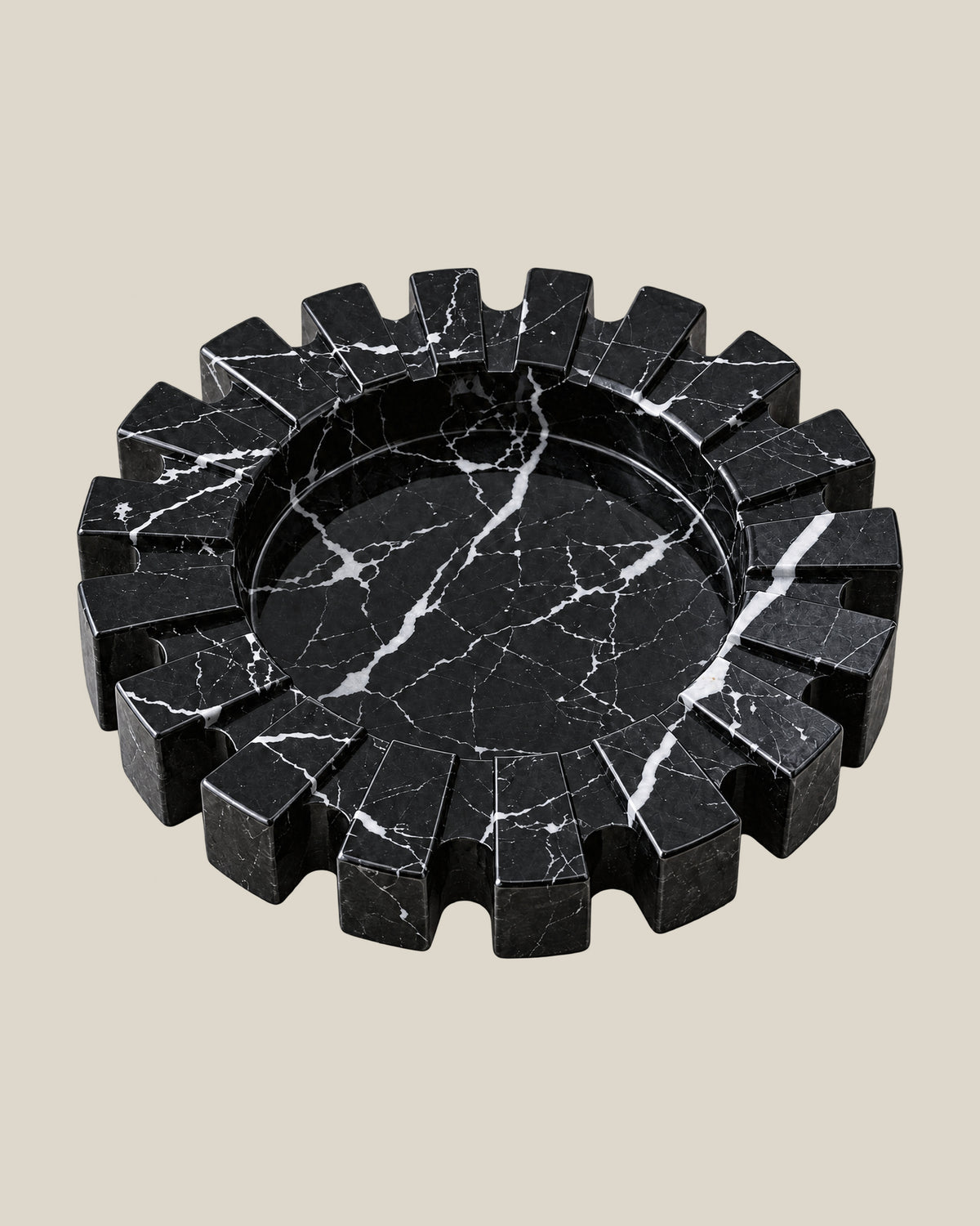 Aston Ash Tray in Spanish Black Marble, three-quarter view showing the carved notched rim and recessed centre.