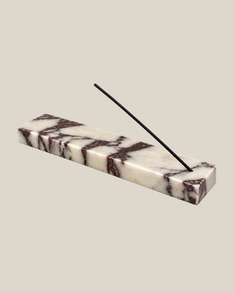 Three-quarter view of LINEA Incense Holder in Calacatta Viola marble, with an unlit incense stick.