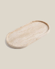 ATOMS OVAL Tray in beige travertine, angled view on a BONE background
