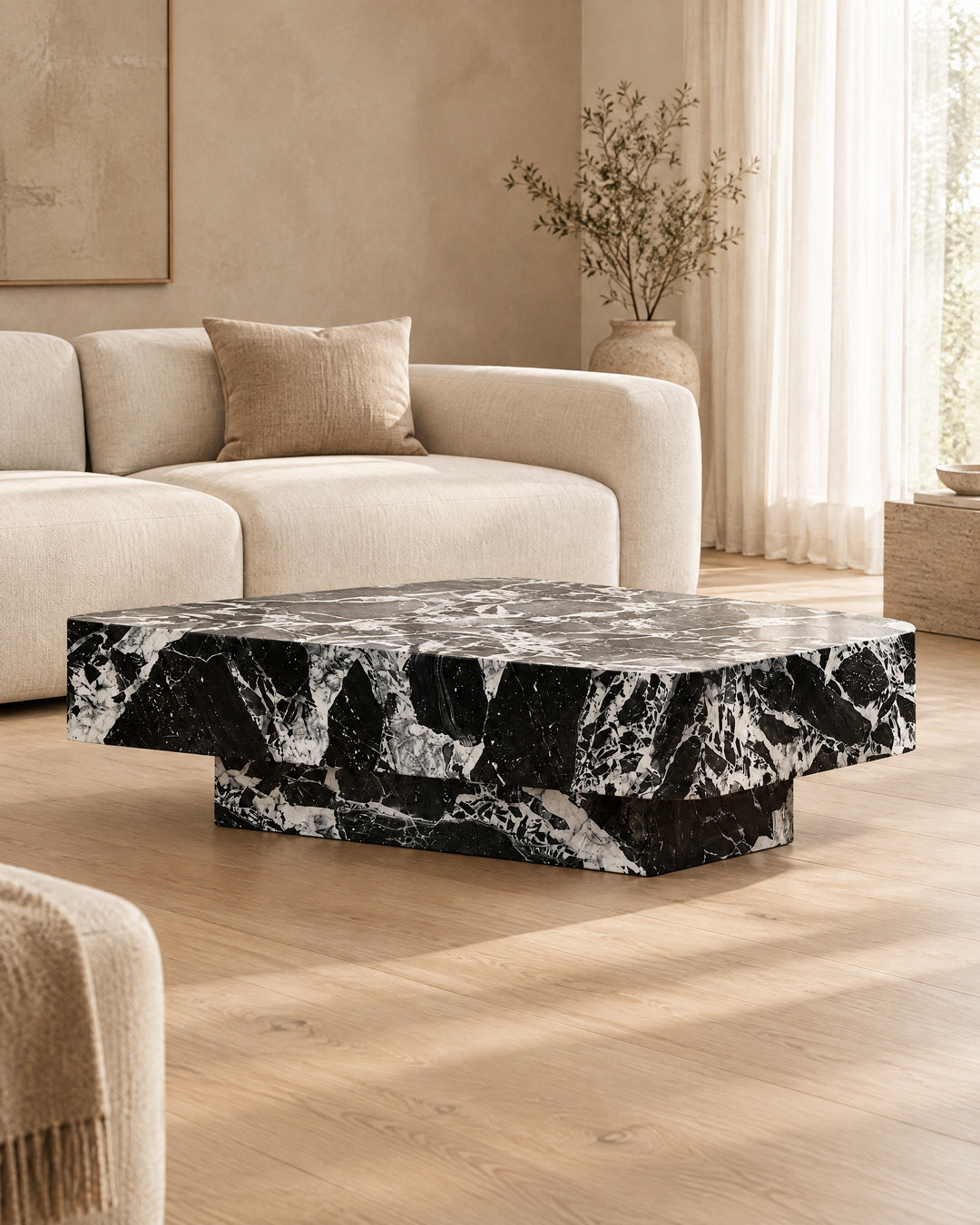 BUTTER coffee table by CARVINGS in Grand Antique Black Marble, in a styled living room, right view.