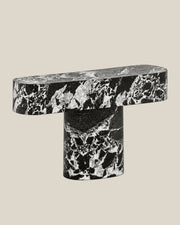 BUTTER console table by CARVINGS in Grand Antique Black Marble, on a BONE background, left view.