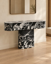 BUTTER console table by CARVINGS in Grand Antique Black Marble, in a styled interior, left view.