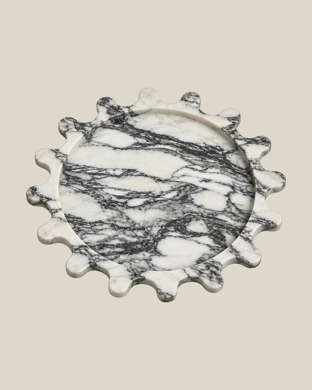 Sun Orbit Tray in Arabescato natural marble, three-quarter view, rounded sun rays and recessed circular centre.