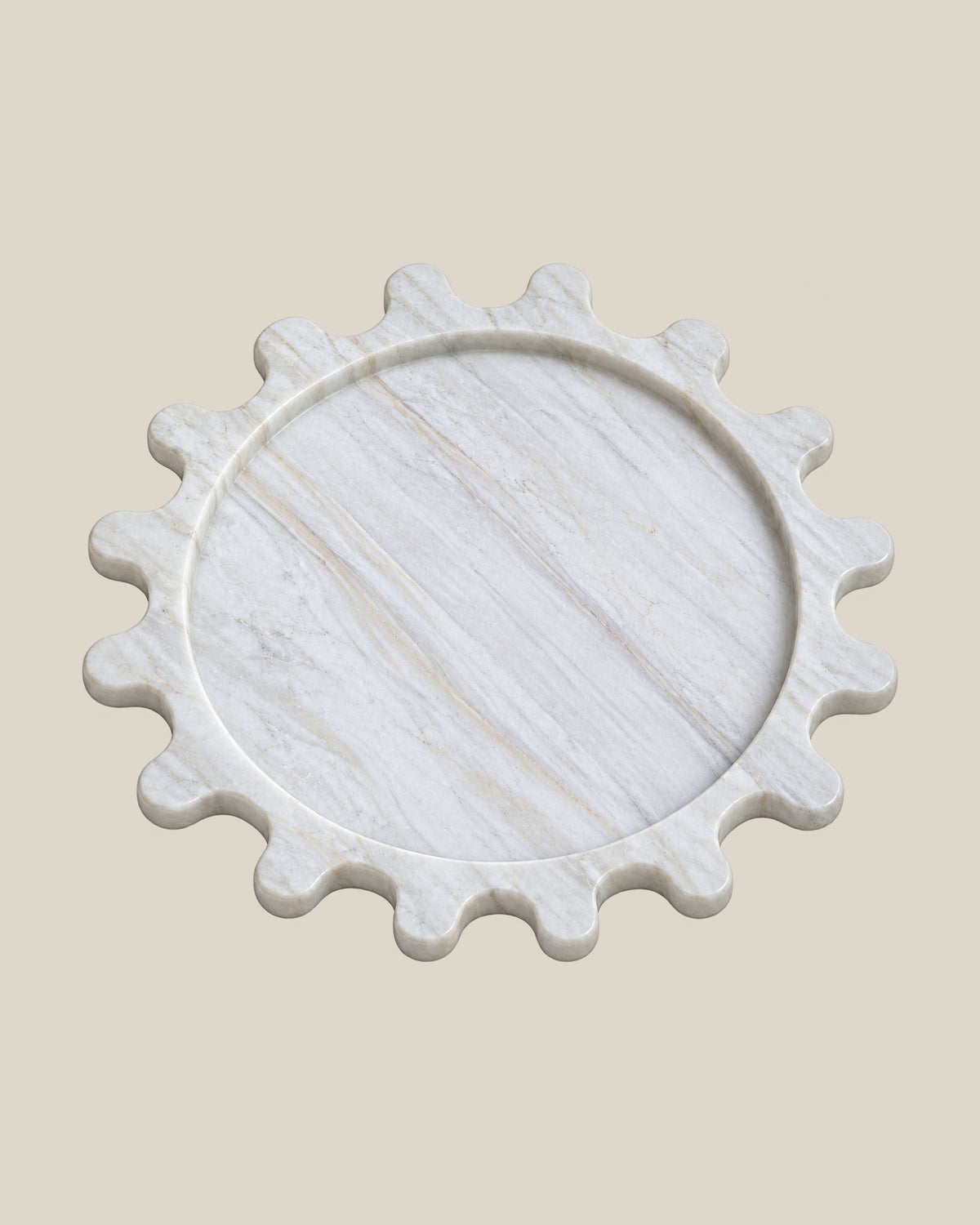 Sun Orbit Tray in Calacatta Gold natural marble, three-quarter view, rounded sun rays and recessed circular centre.